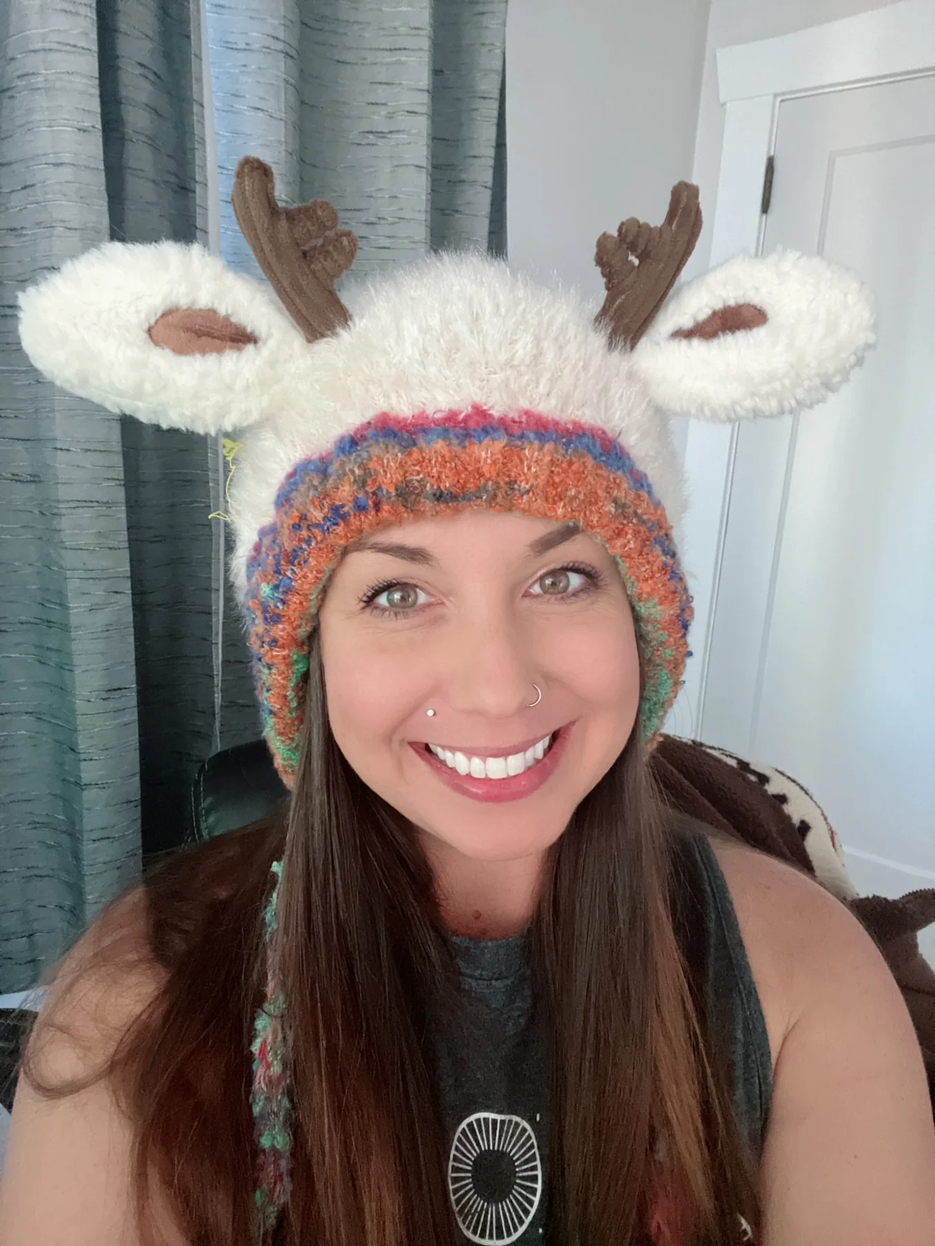 Stacey smiling in a playful fuzzy reindeer hat